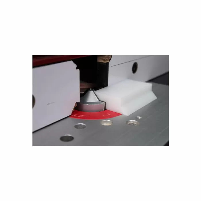 Router table with fence setup and chamfer router bit cutting wood for precise woodworking