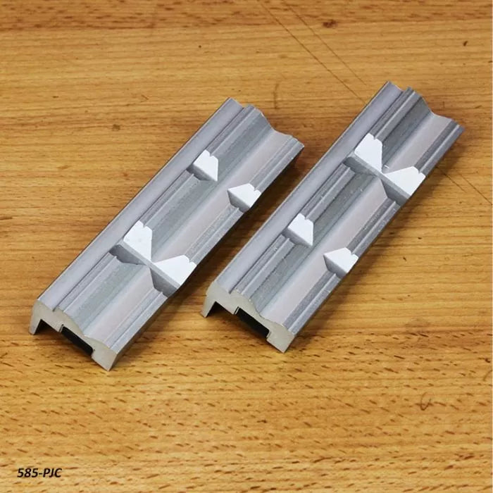 Pair of aluminum wood jointer knife jigs on a wooden surface for woodworking precision