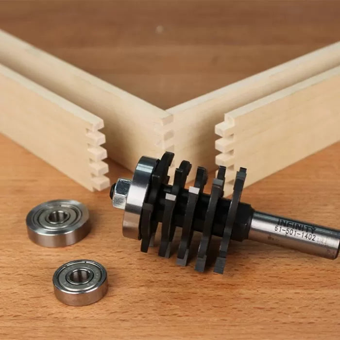 Router bit set and bearings for box joint woodworking on wooden table with jointed boards