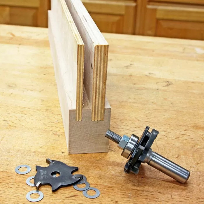 Router bit set with spacers and plywood on a woodworking bench, perfect for joinery cuts