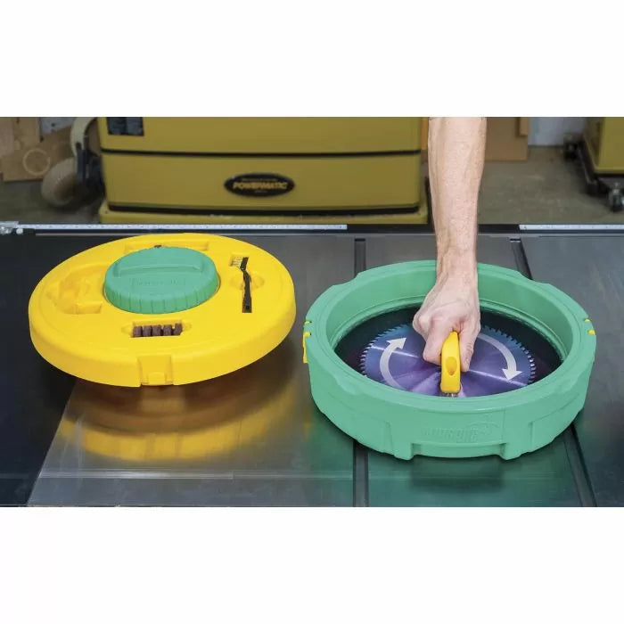 Hand using a circular saw blade cleaning tool on a workbench, with storage case nearby.