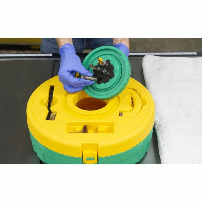 Person cleaning router bits using a yellow and green blade cleaning tool