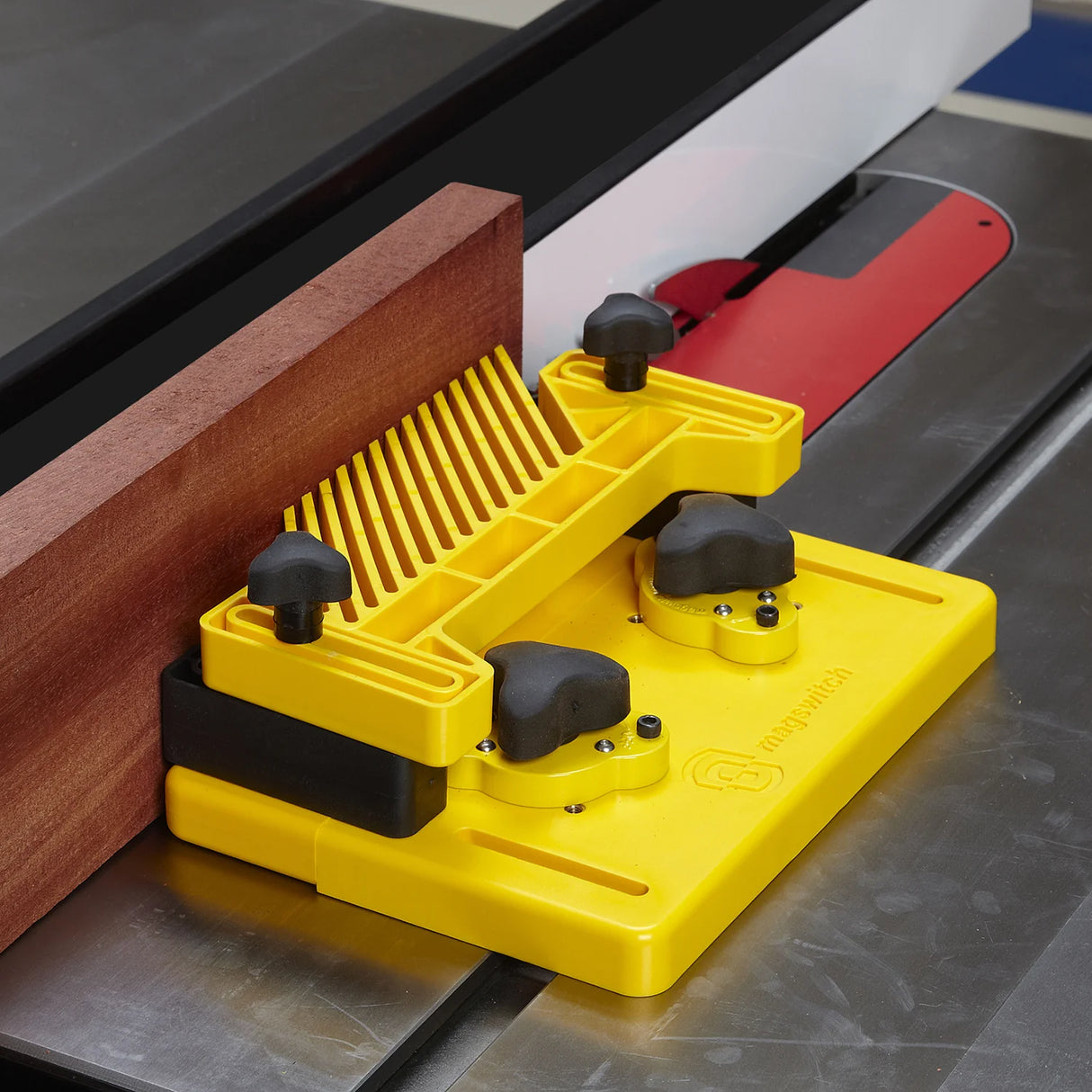 Table saw featherboard holding wood against a fence, promoting woodworking safety and precision.