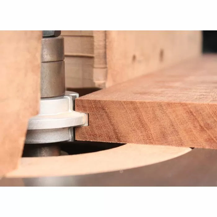 Router bit cutting hardwood edge on router table for woodworking precision