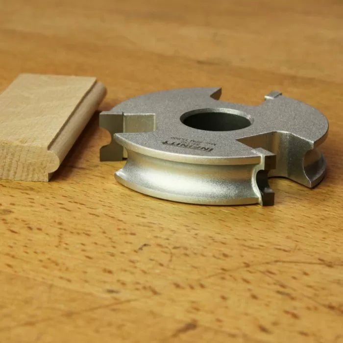 Display cutter woodworking tool with finished wood molding profile on a wooden surface