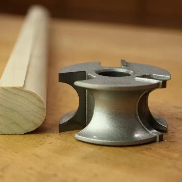 Woodworking edge profile cutter head with finished rounded wooden trim on workbench