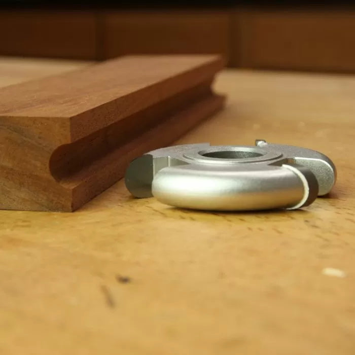 Display cutter for woodworking with finished profile and wooden molding on workbench