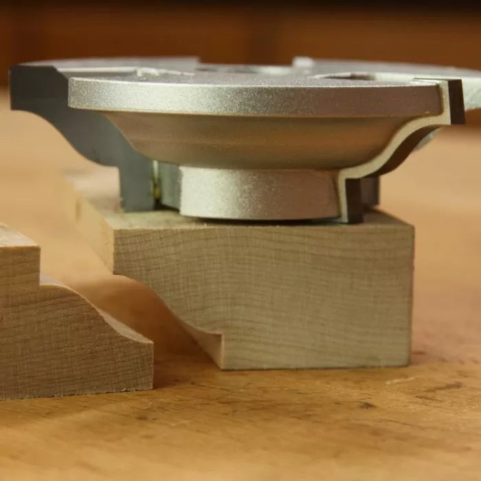 Display cutter tool with finished wood molding profile on a workbench, woodworking accessory