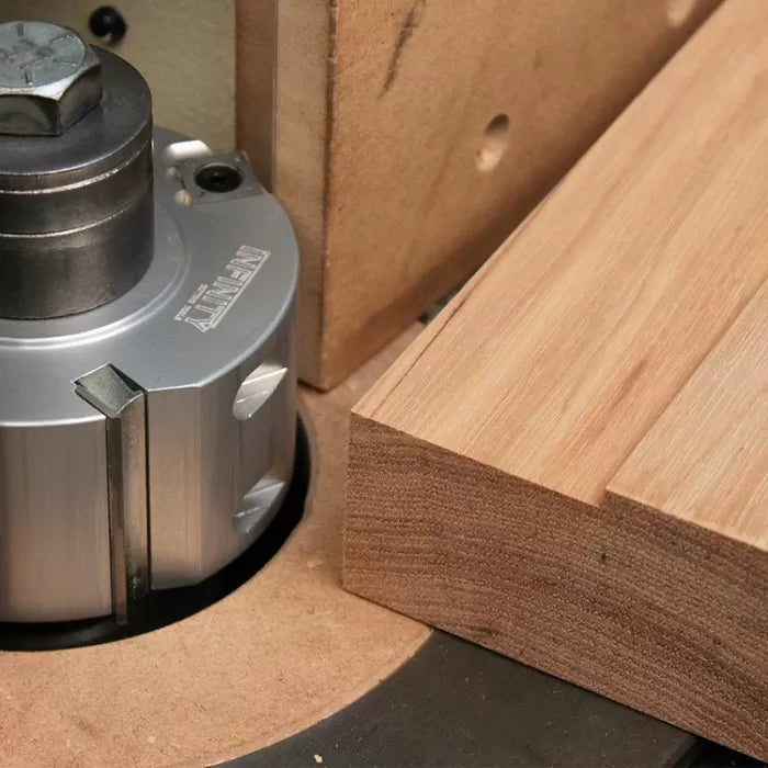 Router table setup with insert cutter and wood board, woodworking tool detail