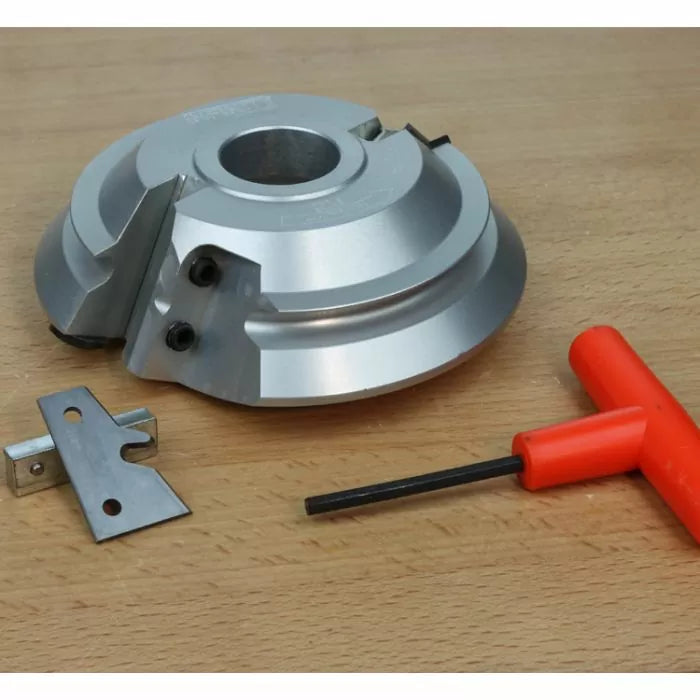 Aluminum woodworking cutter head set with blade and hex key on a wooden surface.