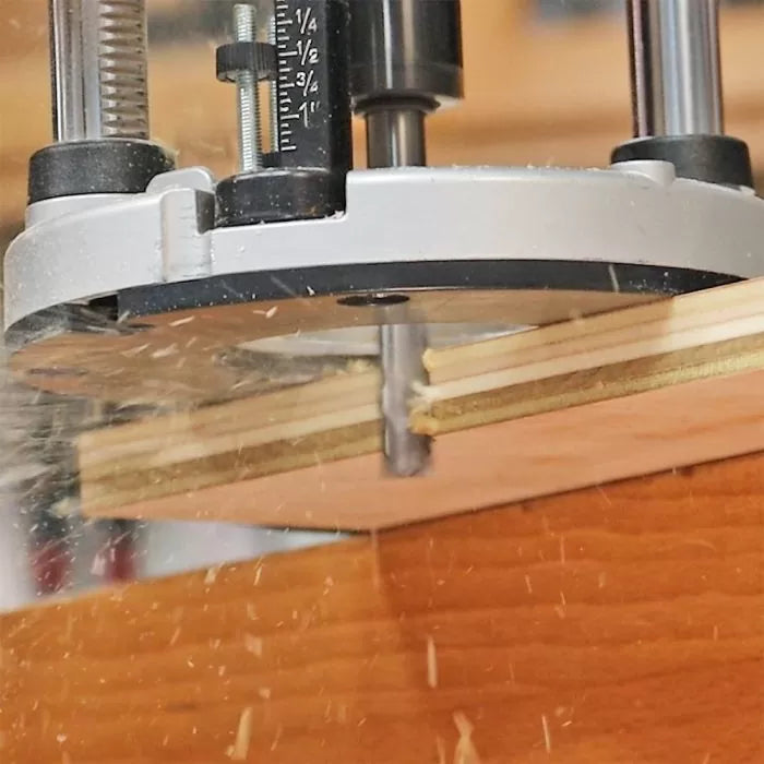 Plunge router cutting plywood with precise depth adjustment, wood shavings flying
