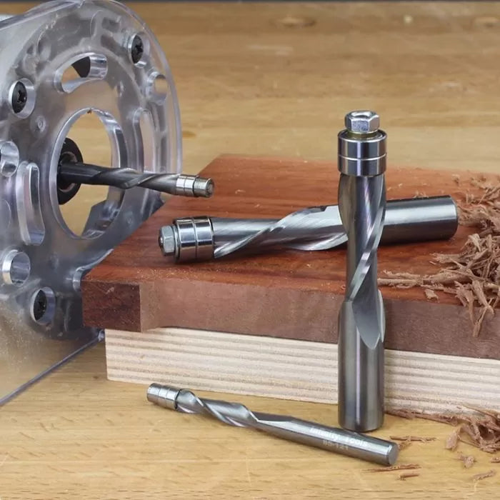 Carbide spiral router bits and router base on wood, woodworking tool detail