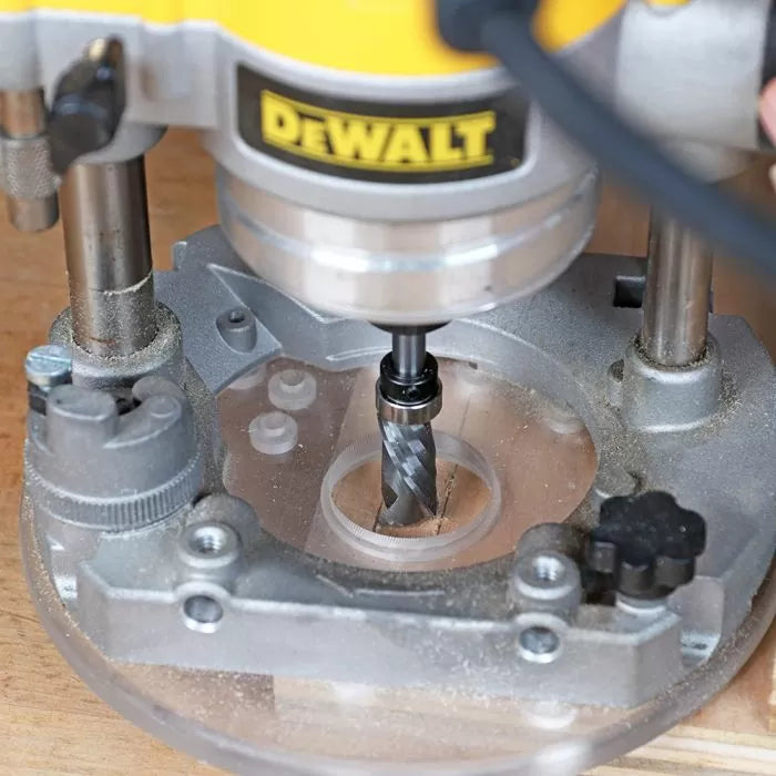 Close-up of a router with spiral bit cutting wood, woodworking tool in use