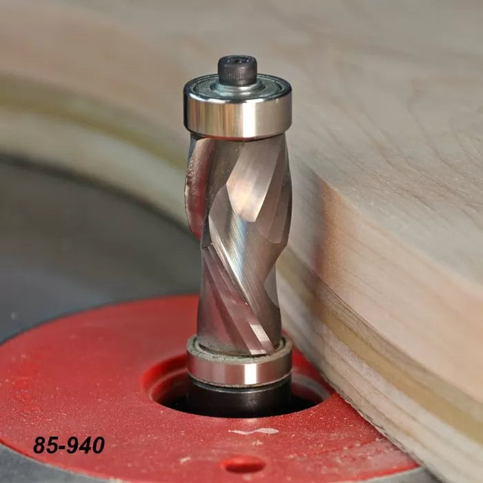 Spiral flush trim router bit cutting wood on a router table for precise woodworking