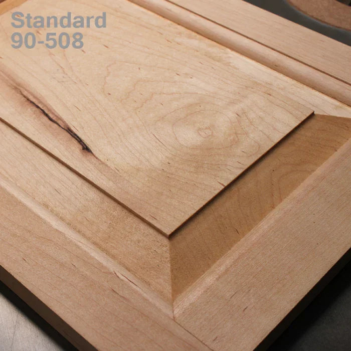 Close-up of a wooden cabinet door panel with beveled edges and natural wood grain texture.