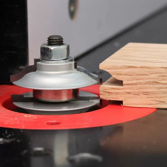 Woodworking router bit cutting decorative edge on wood board