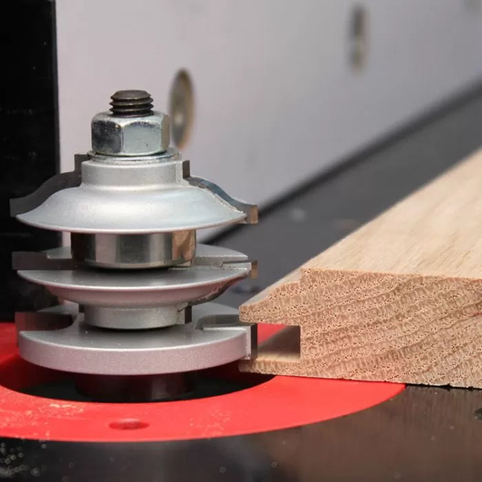 Woodworking router table with stacked rail and stile router bit cutting hardwood edge
