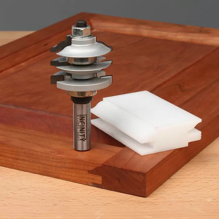 Stacked router bit set for woodworking joinery on a wooden board with white spacers