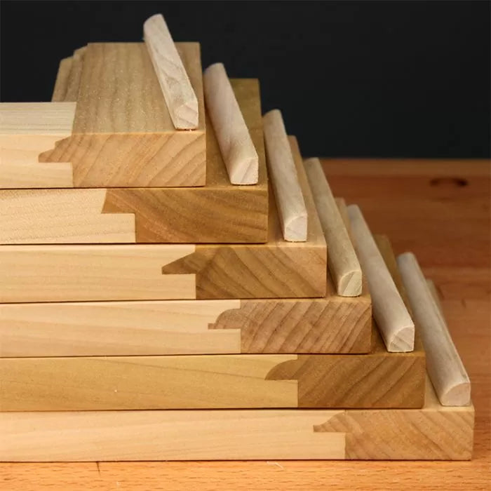 Stack of wooden boards with bullnose edges, woodworking router bit profiles display