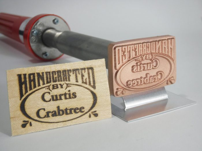 Wood branding iron tool with engraved brass head and branded wood sample for woodworking projects