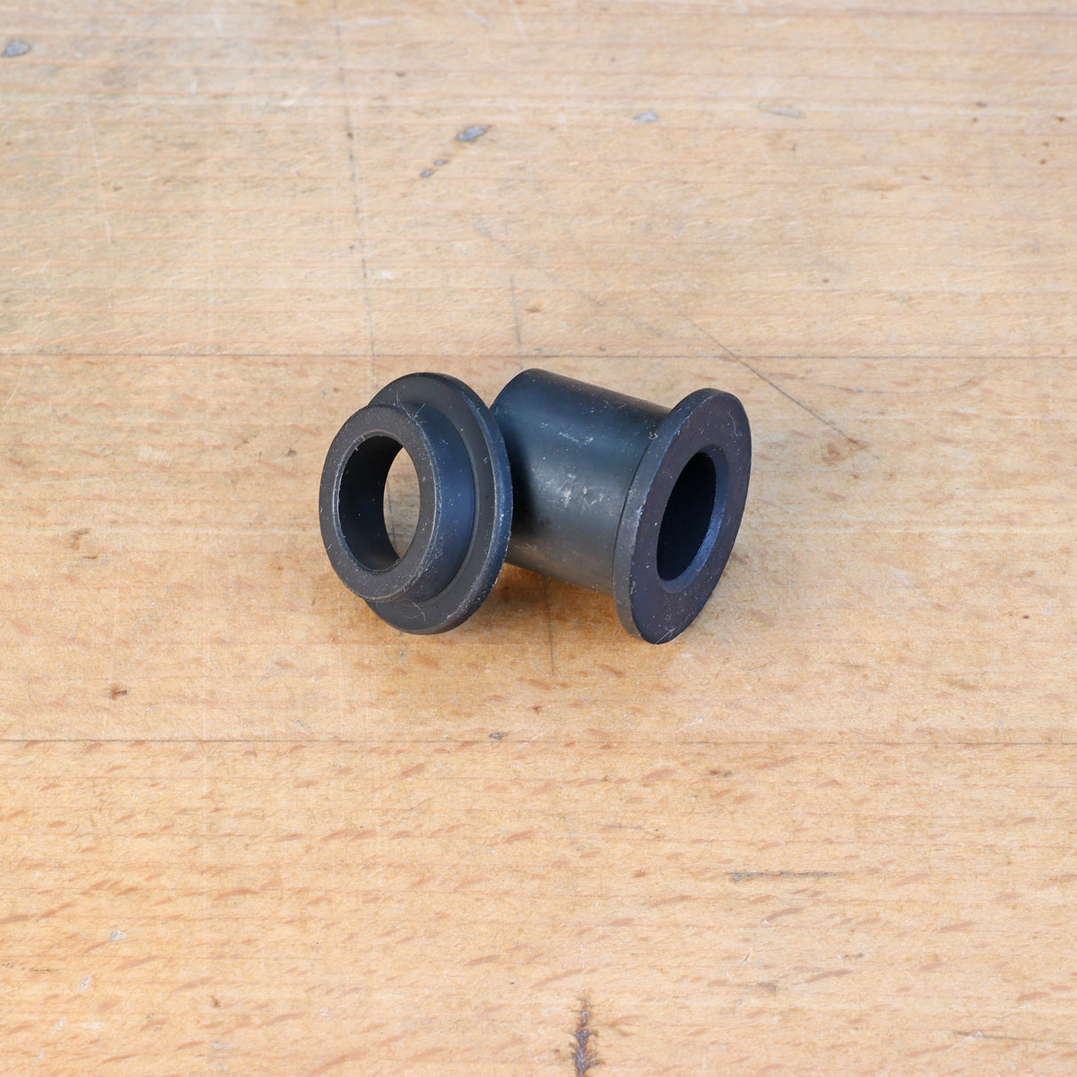 Black router table insert bushing on a wooden surface