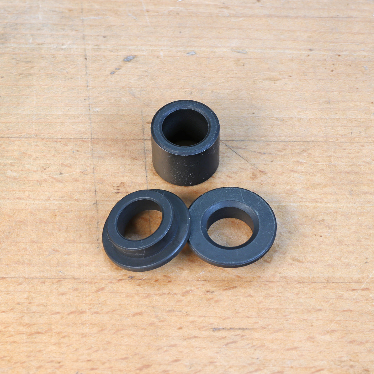 Router guide bushings set on wooden surface for woodworking and routing projects