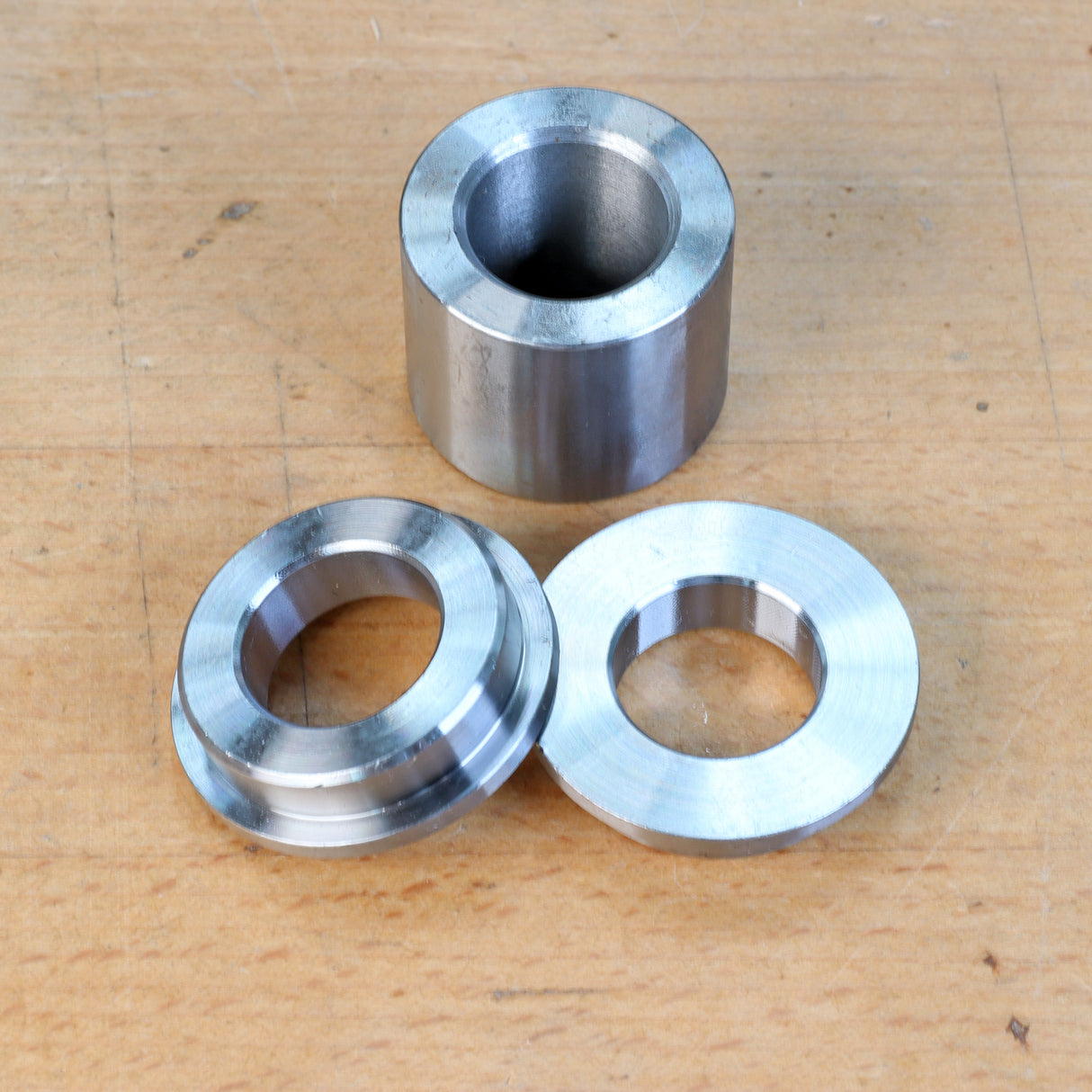 Steel bushings set for woodworking tools on wooden surface