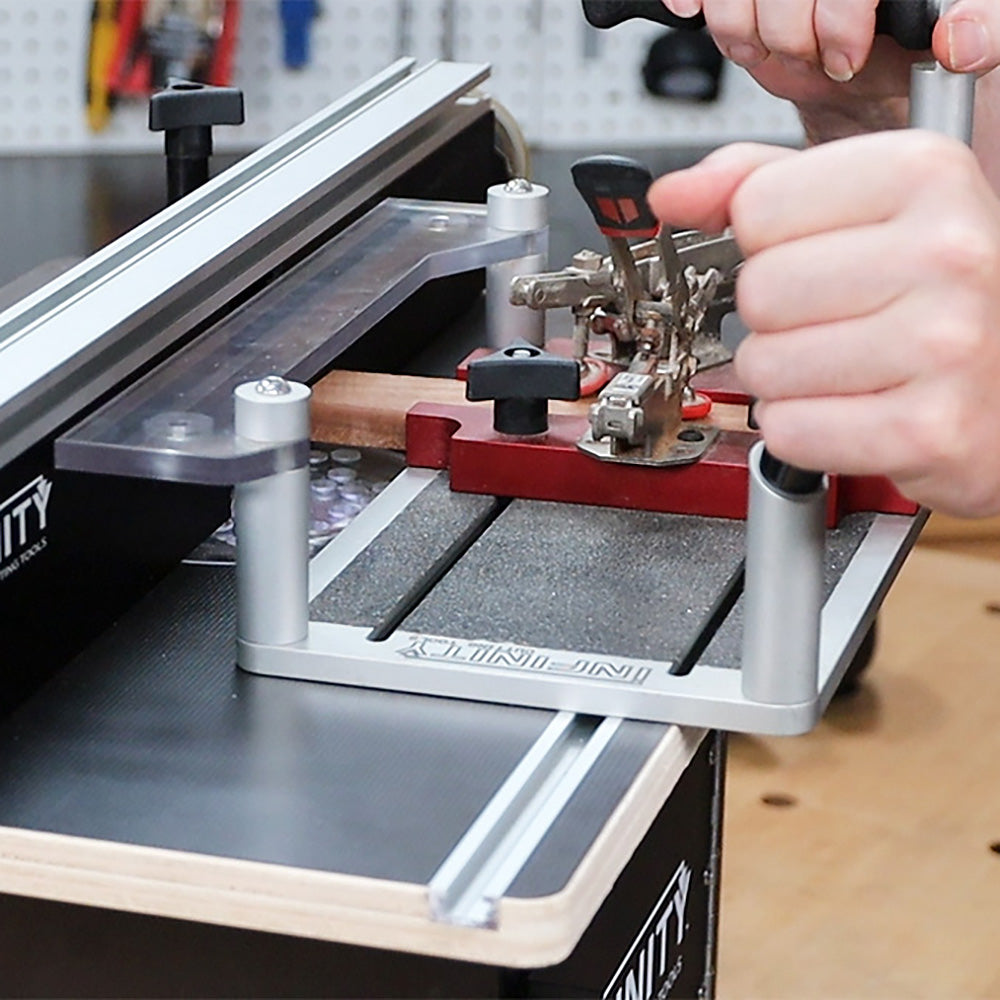 Woodworker using a router table jig to secure wood for precision woodworking cuts