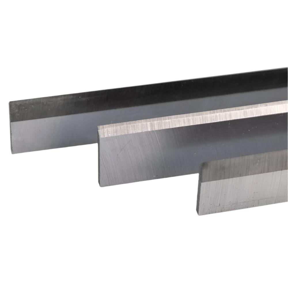 Three precision steel planer blades for woodworking tools, close-up view
