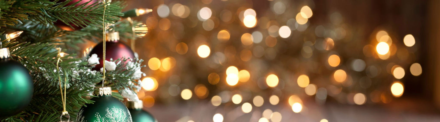 Christmas tree with green and red ornaments, string lights, and festive bokeh background