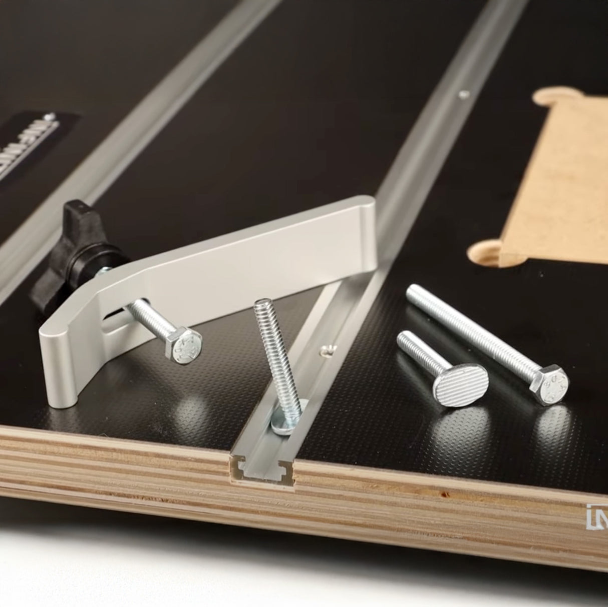 Router table with T-track, aluminum fence, and bolts for woodworking tool setup