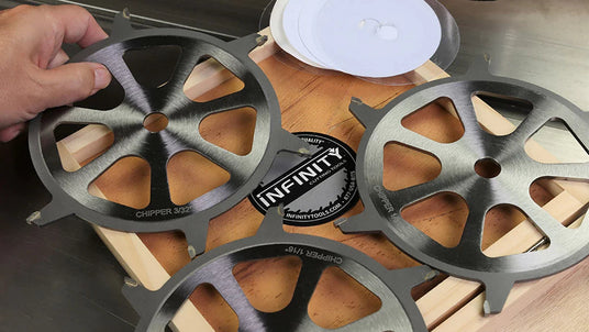 Carbide dado stack chipper blades for table saw, displayed on wood surface with hand.