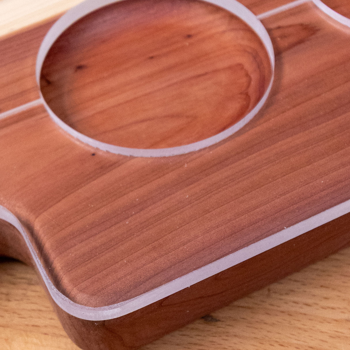 Closeup of a wooden board with precisely routed circular and straight grooves