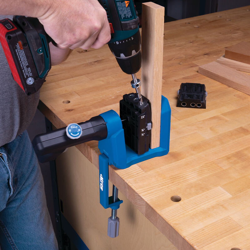 Pocket hole jig clamped to workbench with drill driving screw into wood joinery setup