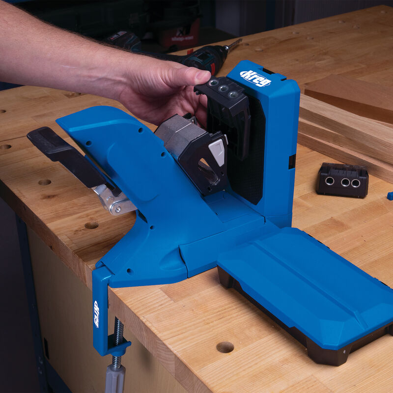 Blue pocket hole jig clamped to workbench for woodworking, hand adjusting tool
