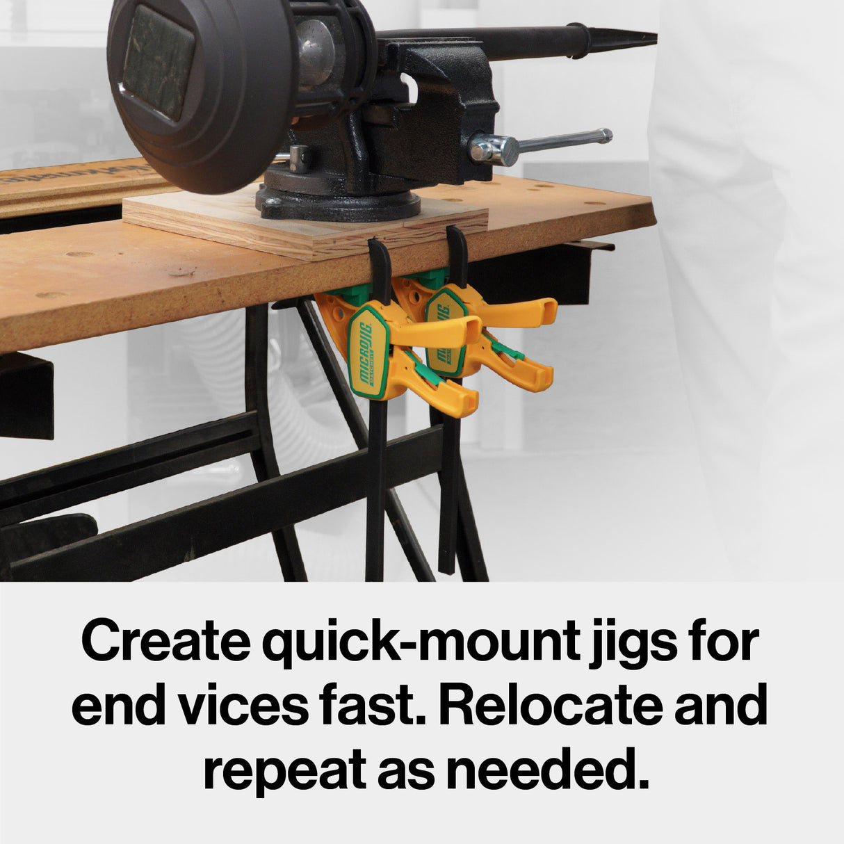 Workbench with vise and two quick-mount woodworking clamps attached underneath.