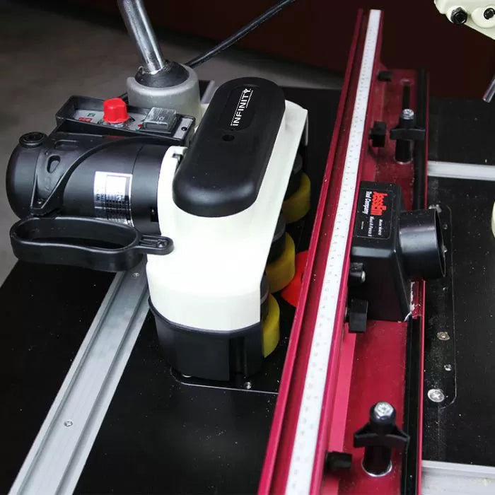 Router table setup with precision router lift, fence, and motorized feed system for woodworking.