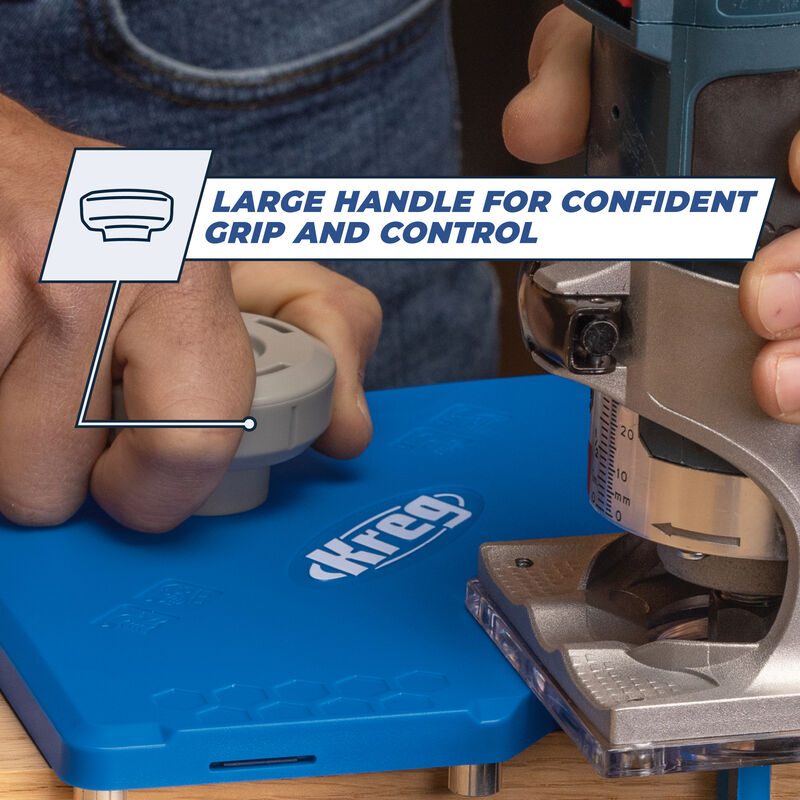 Close-up of hands using a router tool on a blue Kreg woodworking jig with large handle for grip