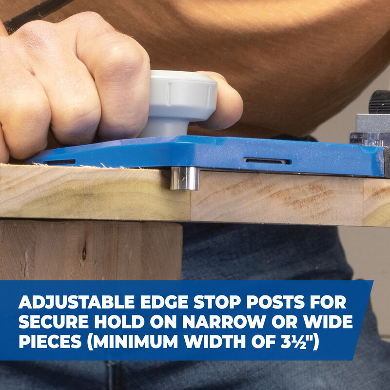 Hand using a woodworking jig with adjustable edge stop posts on a wooden board