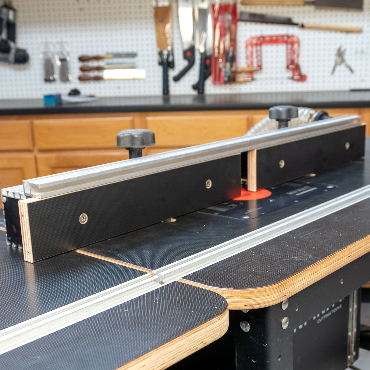 MDF router table fence installed on a router table in a woodworking shop setting.
