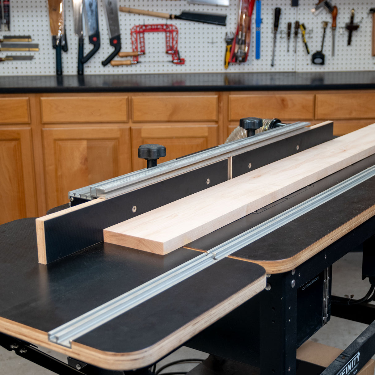 Router table extension fence with MDF faces and wood board in woodworking shop