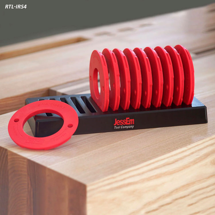 Set of red router table insert rings in a black holder on a wooden workbench
