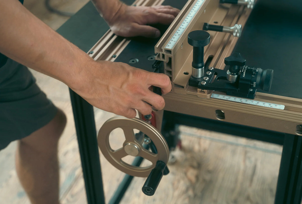 Hand adjusting woodworking router table fence with precise measurement guides
