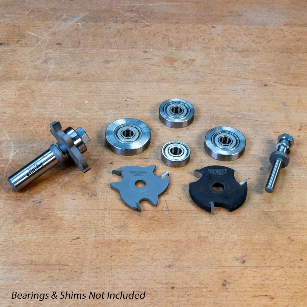 Slot cutter arbors with two blades and bearings on a wooden surface, woodworking tool set.