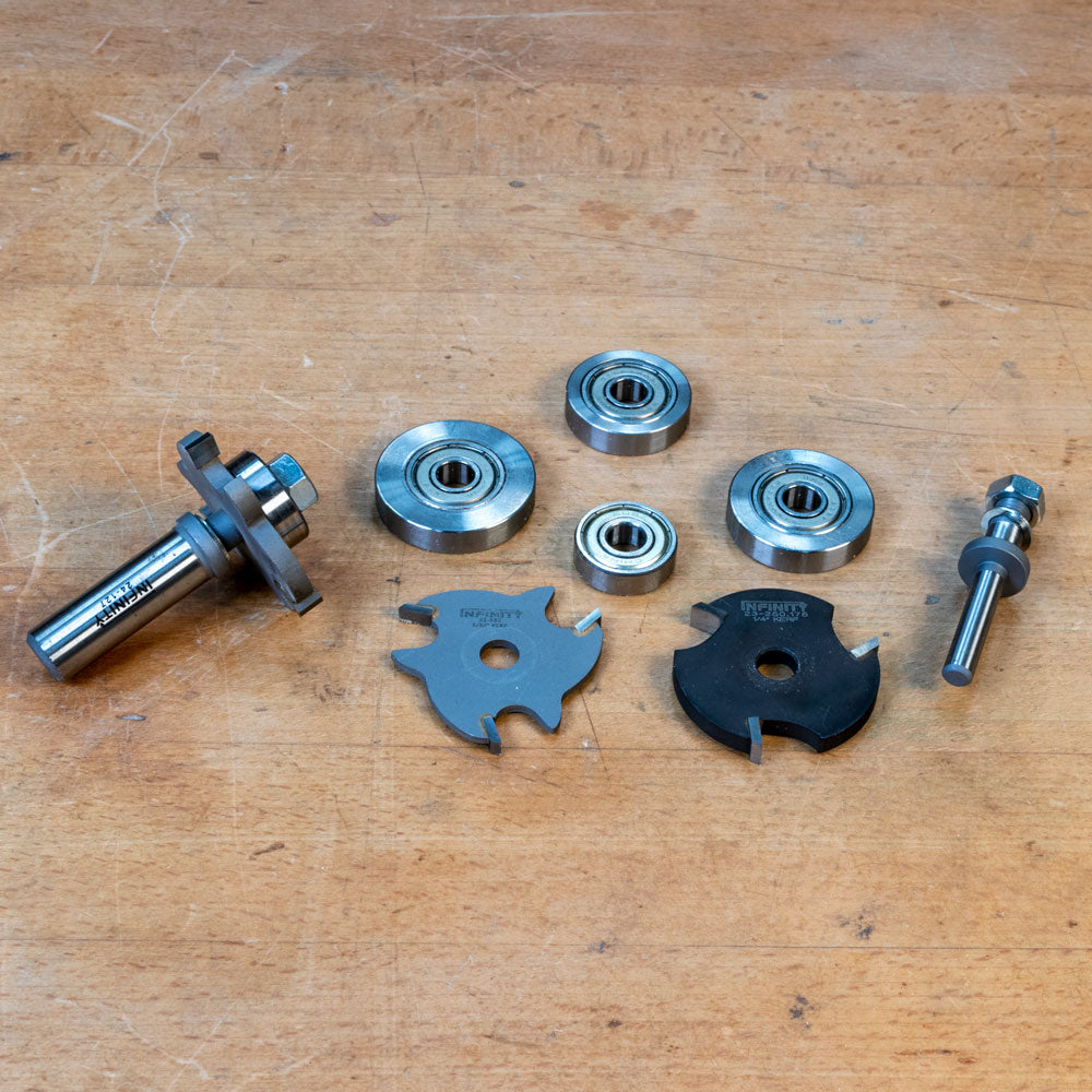 Slot cutter arbor set with bearings and carbide blades on wooden surface for woodworking