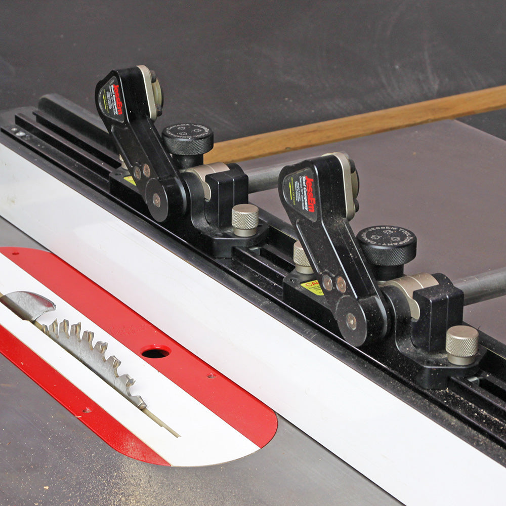Table saw with adjustable featherboard fence system and visible carbide-tipped saw blade