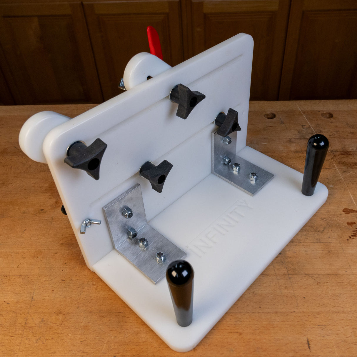 Vertical router sled jig with adjustable clamps and handles on a woodworking bench