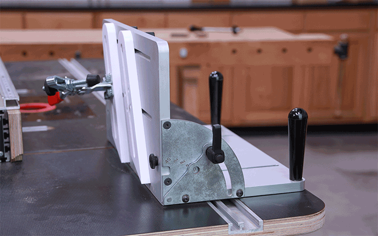 Adjustable woodworking table saw fence jig with handles on workbench in workshop