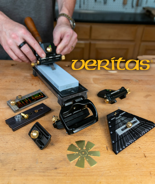 Woodworker using honing guide and sharpening tools on a workbench with Veritas logo