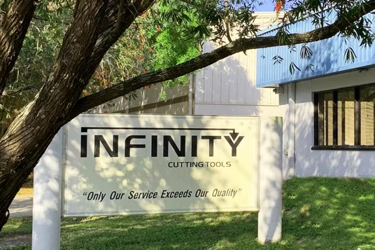 Infinity Cutting Tools sign outside office building with trees and green lawn